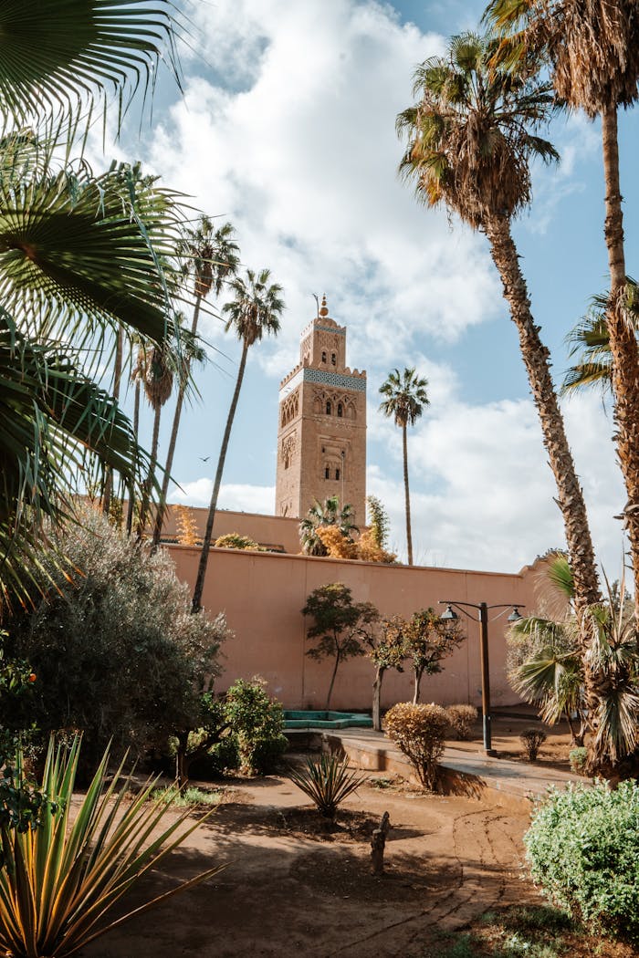 Home View of the Koutoubia Mosque tower surrounded by lush gardens in Marrakech, Morocco.